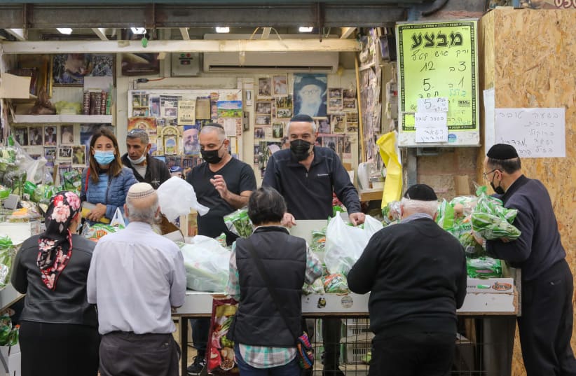Israelis are seen shopping in Jeursalem's Mahane Yehuda amid the coronavirus pandemic, on January 6, 2021. (photo credit: MARC ISRAEL SELLEM/THE JERUSALEM POST)