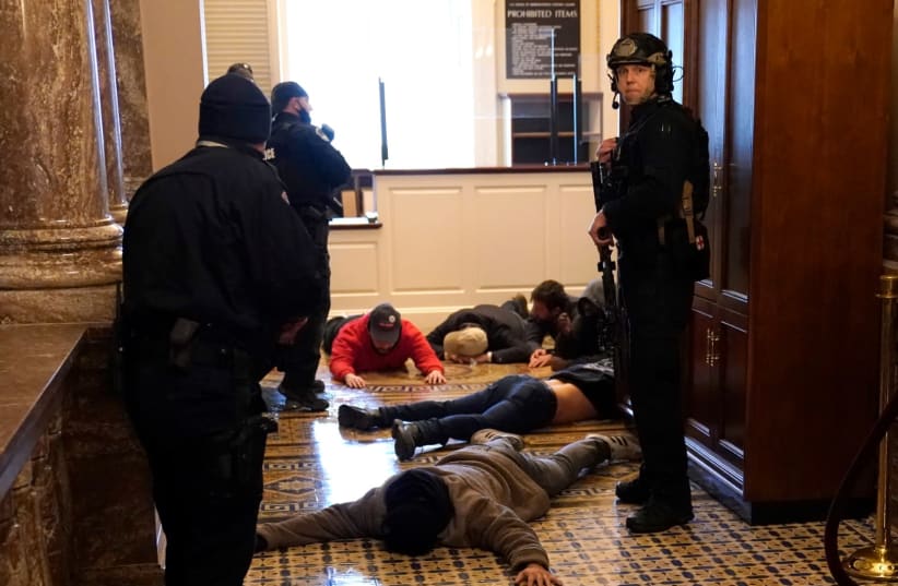 US Capitol Police stand detain protesters outside of the House Chamber during a joint session of Congress on January 06, 2021 in Washington, DC. Congress held a joint session today to ratify President-elect Joe Biden's 306-232 Electoral College win over President Donald Trump. A group of Republican  (photo credit: DREW ANGERER / GETTY IMAGES)