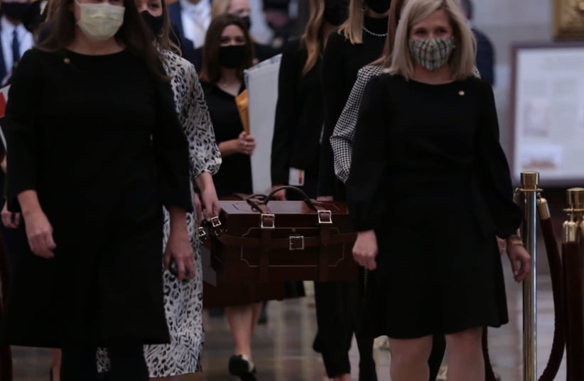 US Senate staff carry boxes containing state Electoral College votes at the US Capitol, Jan. 6, 2021. Brennan Leach, a Northwestern student whose photo went viral, is second from left, partially obscured.  (photo credit: CHERISS MAY/GETTY IMAGES)