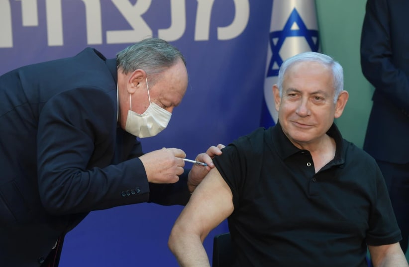 Prime Minister Benjamin Netanyahu receives the second dose of the coronavirus vaccine at Sheba Medical Center, Saturday, January 9, 2020. (photo credit: AMOS BEN GERSHOM, GPO)