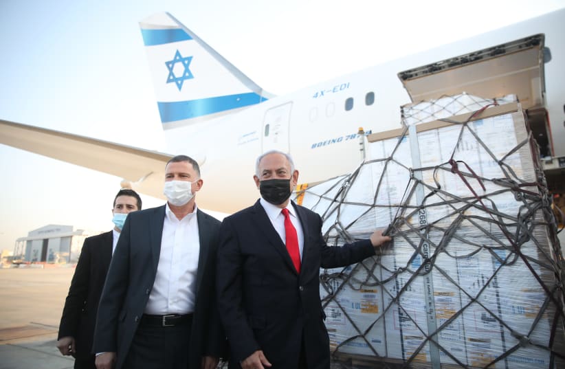 Prime Minister Benjamin Netanyahu and Health Minister Yuli Edelstein receive a shipment of Pfizer coronavirus vaccines, Sunday, January 10, 2020. (photo credit: MOTI MILROD)