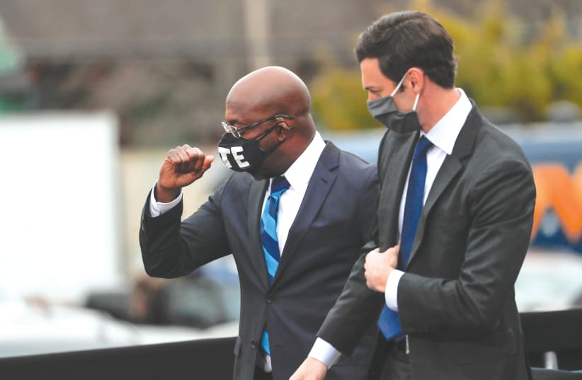 Newly-elected Georgia Senators Rev. Raphael Warnock and Jon Ossoff appear side by side ahead of the January 5 runoff election. (photo credit: MIKE SEGAR / REUTERS)