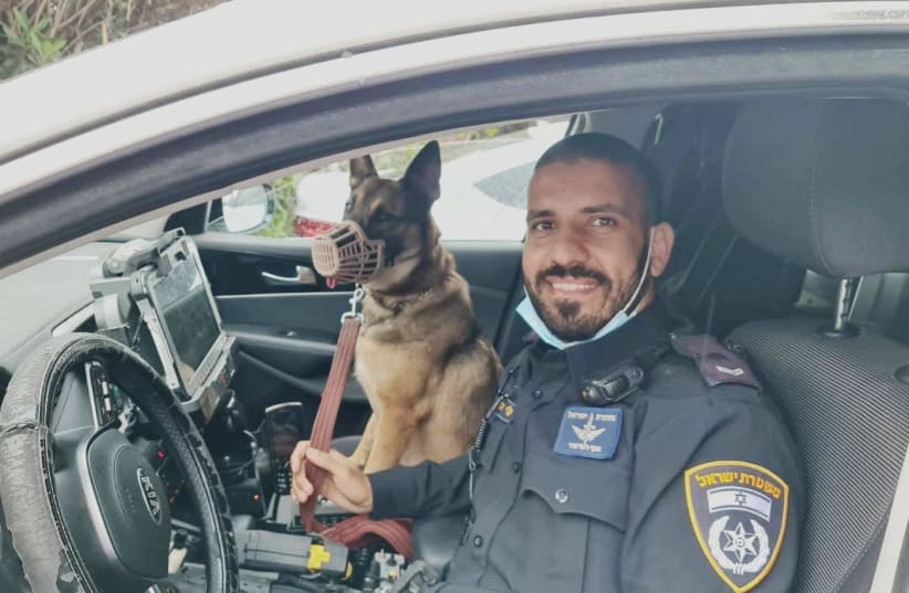 An Israel police officer with famous Israeli actor Shlomo Vishinsky's dog Lisa.  (photo credit: POLICE SPOKESPERSON'S UNIT)