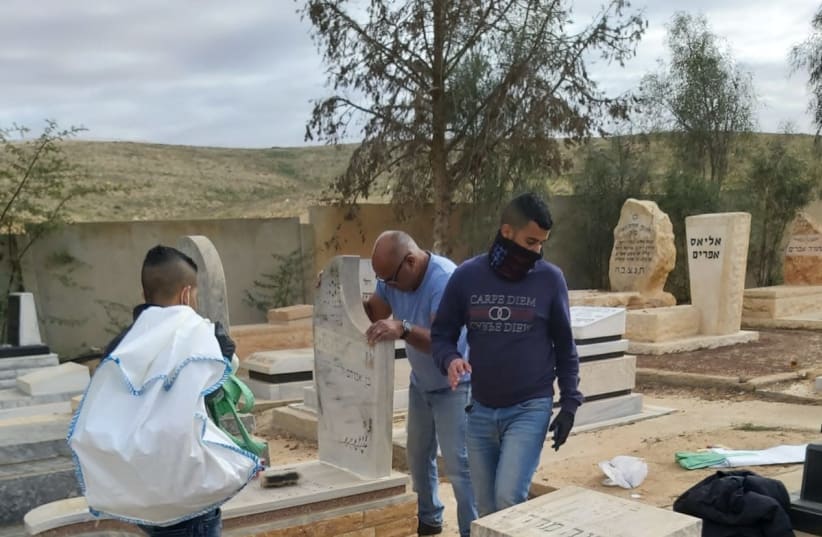 Bedouin youth restore the cemetary in Nevatim after it was vandalized. (photo credit: STARS OF THE SOUTH)