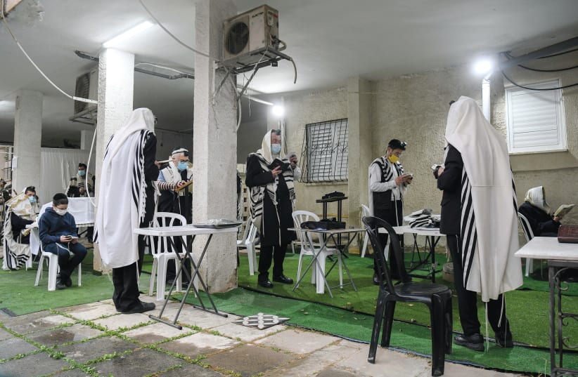 MEN PRAY outside during the third nationwide COVID-19 lockdown, in Bnei Brak on Thursday. (Yossi Zeliger/Flash90) (photo credit: YOSSI ZELIGER/FLASH90)