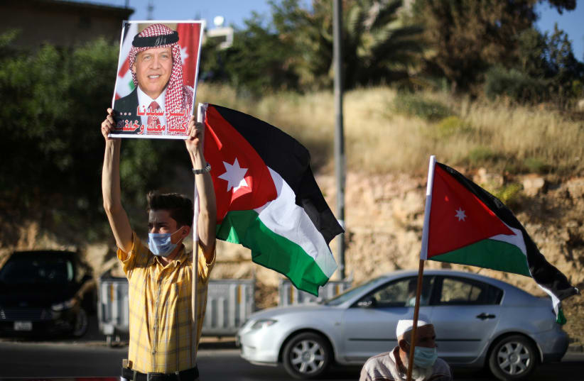 A protester holds a poster of Jordan's King Abdullah as he takes part in a human chain during a sit-in against the annexation of parts of the West Bank by Israel, in Amman, Jordan, June 27, 2020. (photo credit: REUTERS/MUHAMMAD HAMED)