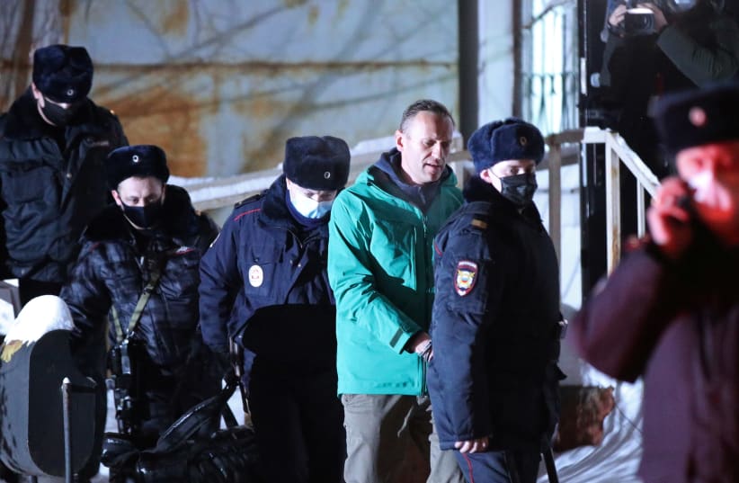 Russian opposition leader Alexei Navalny is escorted by police officers after a court hearing, in Khimki outside Moscow, Russia January 18, 2021. (photo credit: EVGENY FELDMAN/MEDUZA/HANDOUT VIA REUTERS)