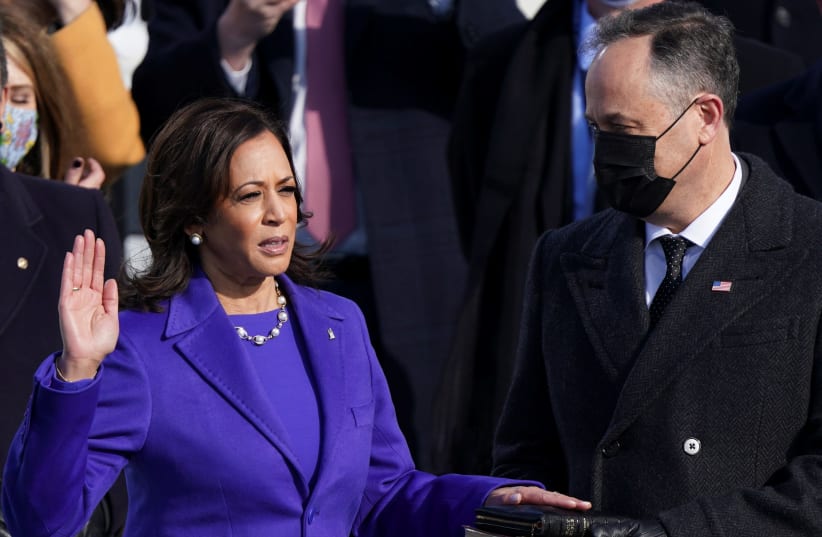 Kamala Harris is sworn in as U.S. Vice President as her spouse Doug Emhoff holds a bible during the inauguration of Joe Biden as the 46th President of the United States on the West Front of the U.S. Capitol in Washington, U.S., January 20, 2021. (photo credit: KEVIN LAMARQUE/REUTERS)