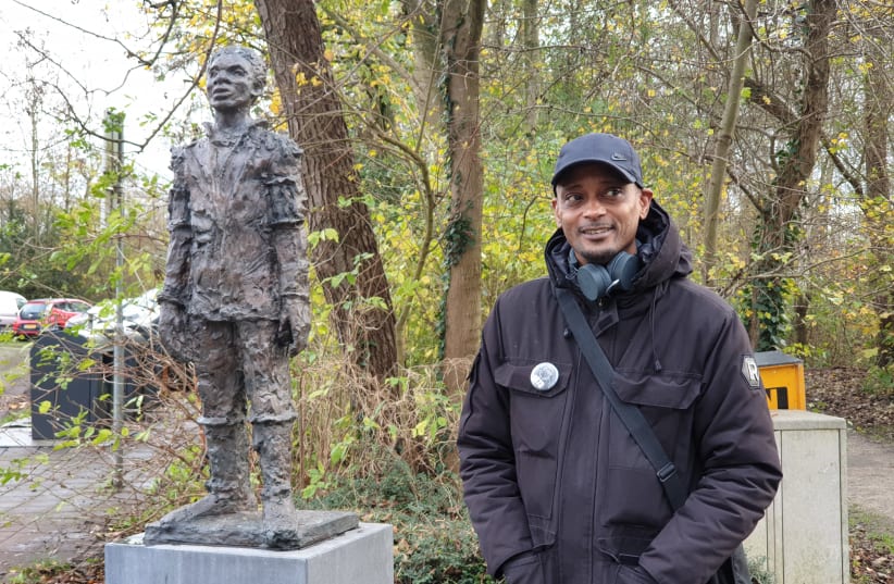 Sergio Berrenstein stands next to the statue of Elieser at the entrance to the Jewish cemetery in Ouderkerk aan de Amstel, the Netherlands on Nov. 20, 2020.  (photo credit: CNAAN LIPHSHIZ/JTA)