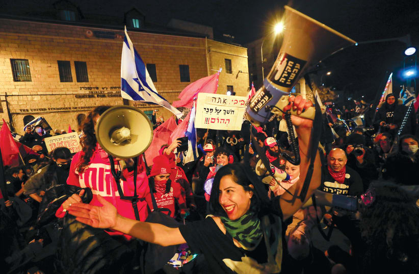 DEMONSTRATORS WITH megaphones in hand on Saturday night, January 16. (photo credit: OLIVIER FITOUSSI/FLASH90)