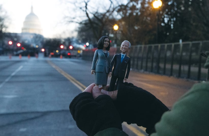 A supporter holds figures of US President Joe Biden and Vice President Kamala Harris outside a barrier in front of the US Capitol in Washington on January 20. (photo credit: CAITLIN OCHS/REUTERS)