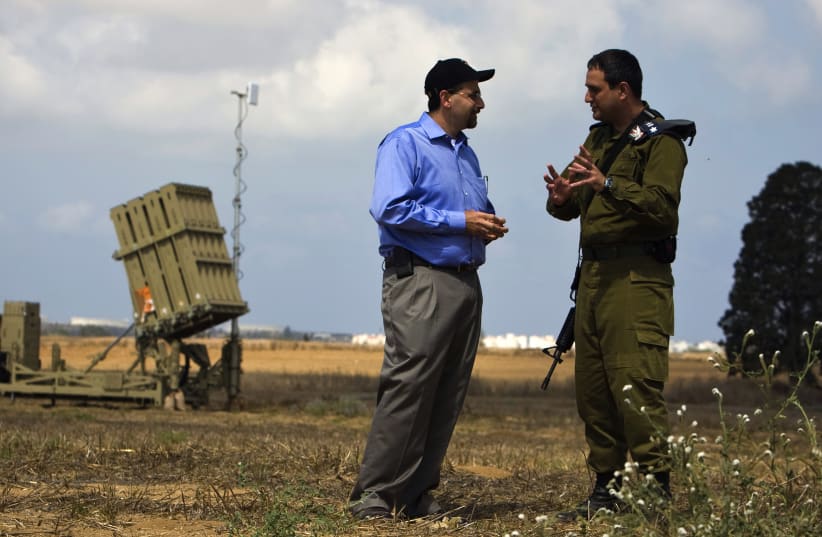Dan Shapiro listens to an IDF officer as they stand next to an Iron Dome launcher in a field near the southern city of Ashkelon. (photo credit: REUTERS)