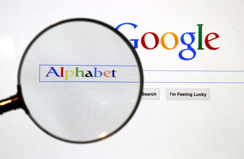 A Google search page is seen through a magnifying glass in this photo illustration taken in Berlin, August 11, 2015. (photo credit: REUTERS/PAWEL KOPCZYNSKI/FILE PHOTO)