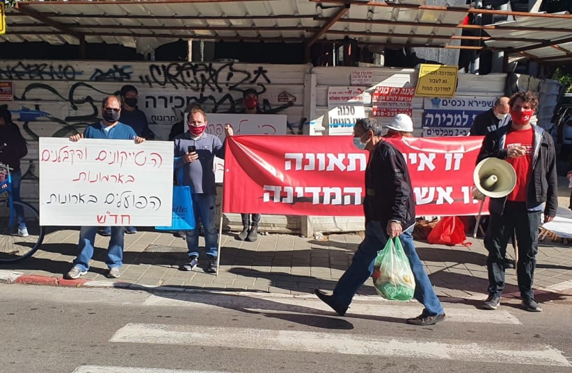Hadash party activists hold banners with the captions “Tycoons and building contractors live in palaces while workers get coffins” and "It is not an accident, it is the fault of the state."    (photo credit: Courtesy)