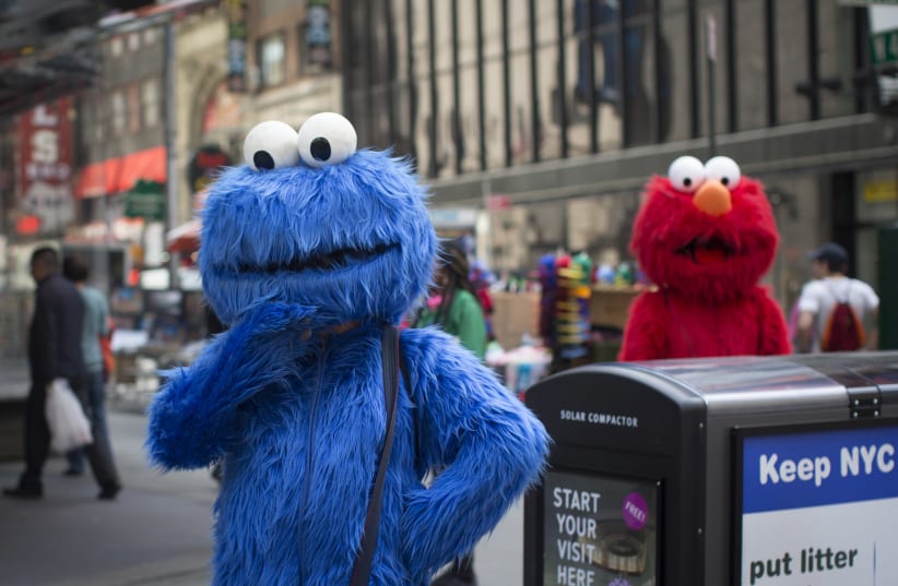 Characters dressed up as the Cookie Monster and Elmo from Sesame Street stand in Times Square while waiting to pose for photographs with people for tips (photo credit: SHANNON STAPLETON/ REUTERS)