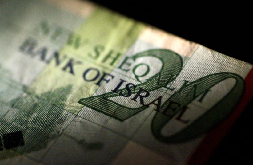 An Israeli shekel note is seen in this June 22, 2017 illustration photo.  (photo credit: REUTERS/THOMAS WHITE/ILLUSTRATION/FILE PHOTO)