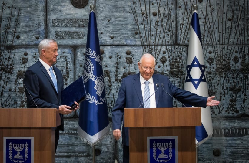 Israeli president Reuven Rivlin presents Blue and White party leader Benny Gantz with the mandate to form a new Israeli government, after PM Netanyahu's failure to form one, at the President's Residence in Jerusalem on October 23, 2019.  (photo credit: YONATAN SINDEL/FLASH 90)