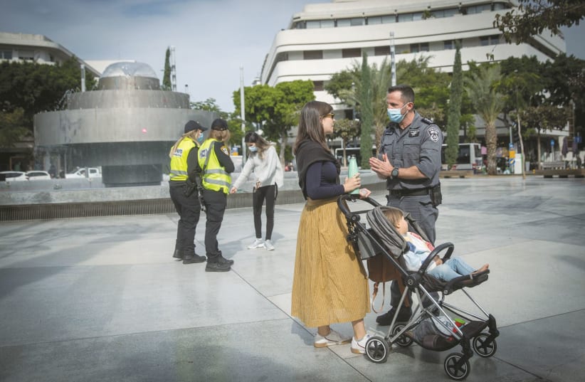 POLICE OFFICERS try to convince passersby to abide by pandemic-related restrictions, in Tel Aviv’s Dizengoff Square on Monday. (photo credit: MIRIAM ALSTER/FLASH90)