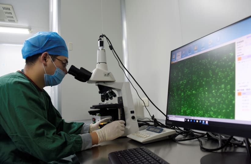 A technician inspects through a microscope a semen sample at a human sperm bank inside a hospital in Hefei, Anhui province, China February 21, 2019.  (photo credit: REUTERS/STRINGER)