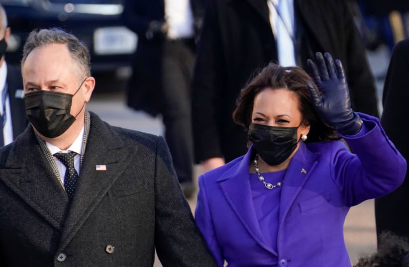 US Vice President Kamala Harris and her husband Douglas Emhoff salute as they walk during the Inauguration Day parade, on January 20.  (photo credit: ERIN SCOTT/REUTERS)