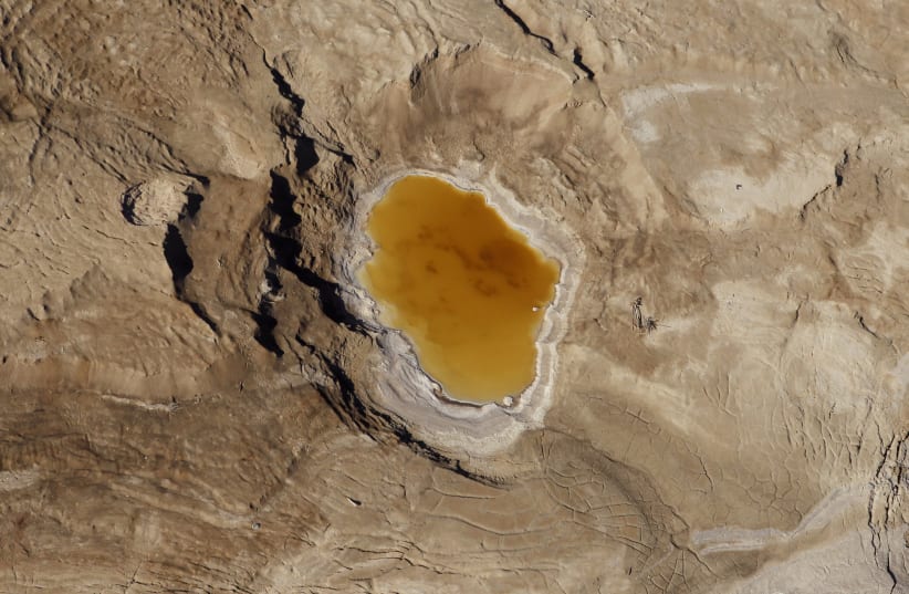 A sink hole filled with water is seen in this aerial view of the Dead Sea December 5, 2011.  (photo credit: BAZ RATNER/REUTERS)