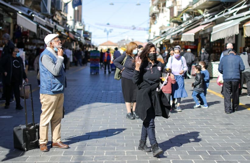 Israelis are seen in Jerusalem's Mahane Yehuda market amid the coronavirus pandemic, on February 2, 2021. (photo credit: MARC ISRAEL SELLEM/THE JERUSALEM POST)
