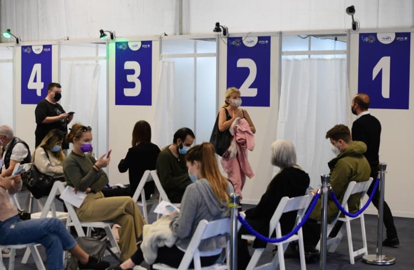 Israelis wait to receive the coronavirus vaccine in Tel Aviv after the Health Ministry announced that anyone over the age of 16 can now be vaccinated, Feb. 4, 2021. (photo credit: AVSHALOM SASSONI/MAARIV)