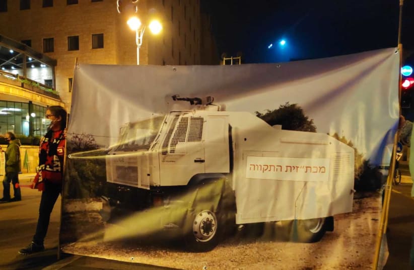 Anti-Netanyahu protesters in Jerusalem addressed police brutality by erecting a large poster showcasing a water cannon vehicle usually used by police to disperse protests alongside the Hebrew caption: "a water cannon vehicle of hope," Saturday, February 6, 2021. (photo credit: EIN MATZAV (“NO WAY”) MOVEMENT)