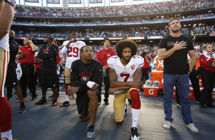 Colin Kaepernick, No. 7, kneels with his teammate Eric Reid during the national anthem prior to a game on Sept. 1, 2016.  (photo credit: MICHAEL ZAGARIS/SAN FRANCISCO 49ERS/GETTY IMAGES)