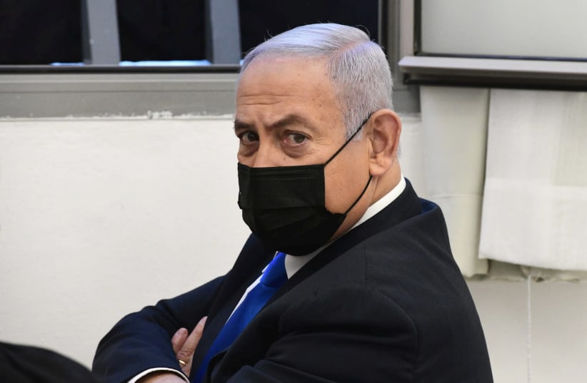 Israeli Prime Minister Benjamin Netanyahu looks on before the start of a hearing in his corruption trial at Jerusalem's District Court February 8, 2021 (photo credit: REUVEN KASTRO/POOL)