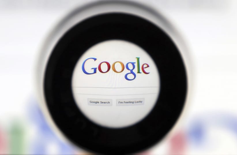 A Google search page is seen through a magnifying glass in this photo illustration taken in Brussels (photo credit: FRANCOIS LENOIR / REUTERS)