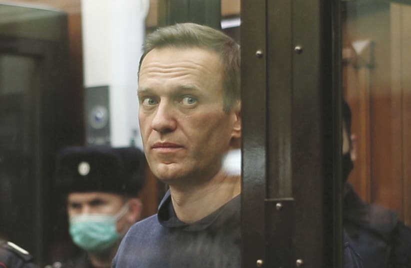 RUSSIAN OPPOSITION leader Alexei Navalny, who is accused of flouting the terms of a suspended sentence for embezzlement, inside a defendant dock during the announcement of a court verdict in Moscow, Russia earlier this month. (photo credit: REUTERS)