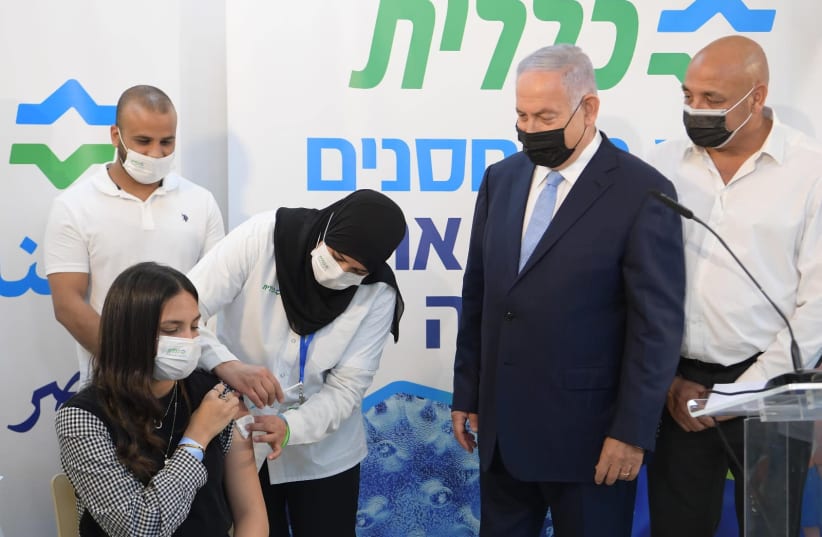 Prime Minister Benjamin Netanyahu visits Clalit vaccination center in the Arab town of Zarzir with Health Minister Yuli Edelstein to help encourage vaccination among the Arab population. (photo credit: AMOS BEN GERSHOM, GPO)