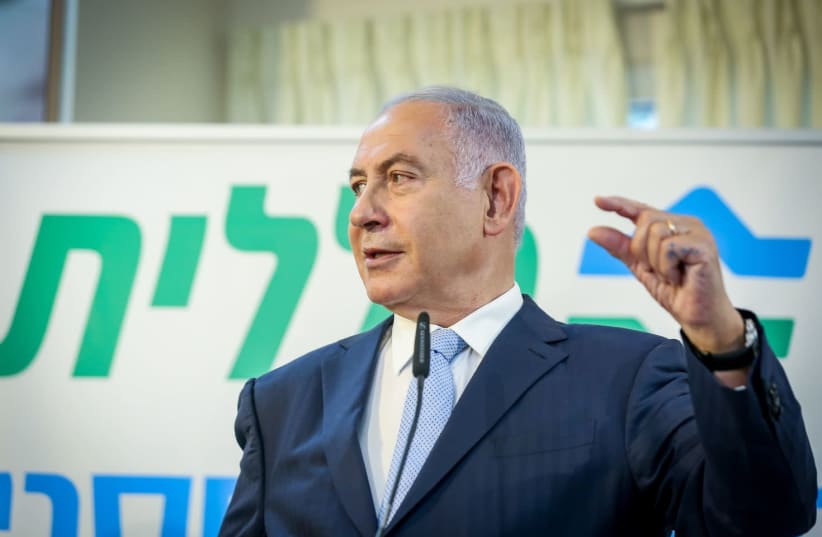 Prime Minister Benjamin Netanyahu is seen gesturing at a Clalit vaccination center in Zarzir, on February 9, 2021. (photo credit: DAVID COHEN/FLASH 90)