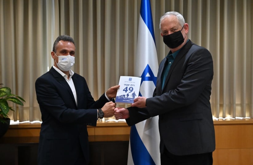 Defense Minister Benny Gantz and  Brig-Gen. (ret.) Eitan Dahan hold the report (photo credit: ARIEL HERMONI / DEFENSE MINISTRY)