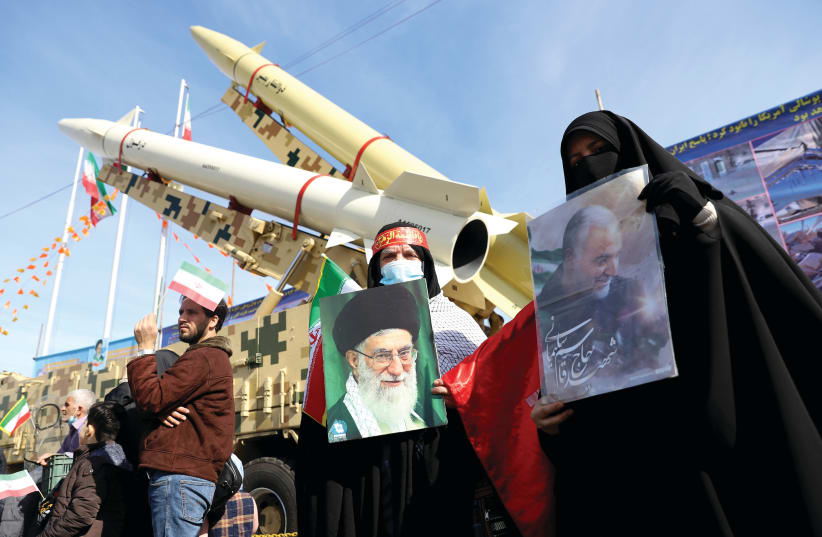 IRANIAN WOMEN hold pictures of Supreme Leader Ayatollah Ali Khamenei and the late Iranian Lt.-Gen. Qasem Soleimani, during the celebration of the 42nd anniversary of the Islamic Revolution, in Tehran on Wednesday. (photo credit: MAJID ASGARIPOUR/WANA (WEST ASIA NEWS AGENCY) VIA REUTERS)