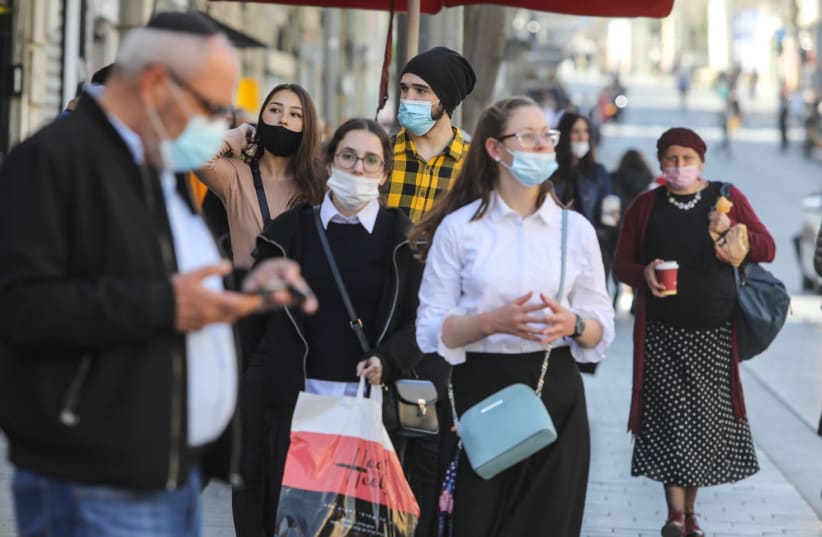 Jerusalem residents, with COVID-19 masks, waiting for the bus  (photo credit: MARC ISRAEL SELLEM)