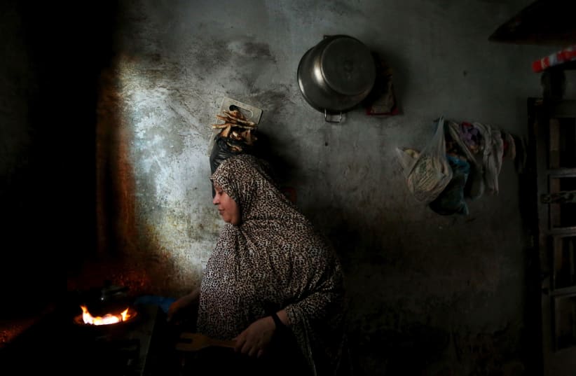 A Palestinian woman makes tea inside her house during power cut at Shatti (beach) refugee camp in Gaza City July 23, 2015. Palestinian Energy officials said residents of Gaza (photo credit: REUTERS)