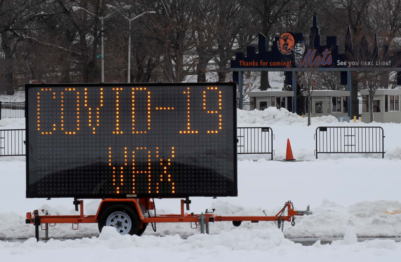 A sign saying 'COVID-19 VAX' is seen outside Citi Field, the home stadium of the MLB's New York Mets, one day ahead of the opening of a portion of the baseball park as a COVID-19 mass vaccination site in Queens, New York (photo credit: BRENDAN MCDERMID/REUTERS)