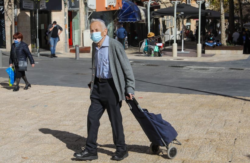 An elderly man walking in Jerusalem wearing a COVID-19 mask  (photo credit: MARC ISRAEL SELLEM)