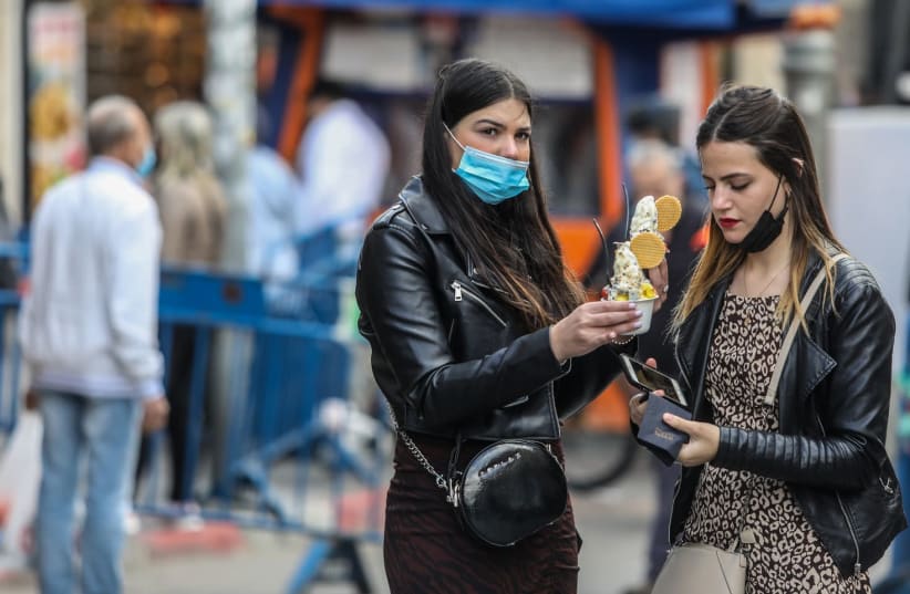 Israelis in Jerusalem are seen with ice cream ahead of an expected snowfall, on February 16, 2021. (photo credit: MARC ISRAEL SELLEM/THE JERUSALEM POST)