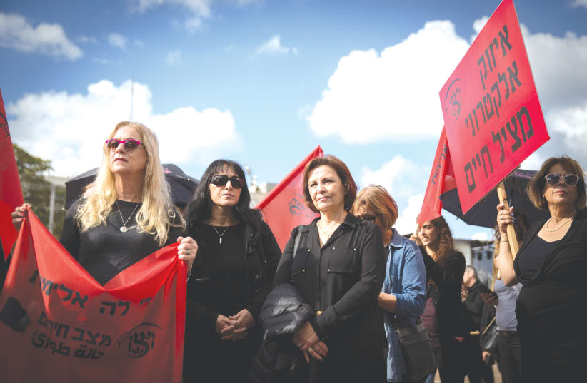 A GROUP of women – one holding a sign that says ‘Electronic bracelets save lives’ – participate in nationwide strike protesting violence against women, in Tel Aviv in 2018. (photo credit: MIRIAM ALSTER/FLASH90)