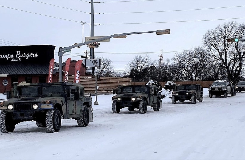 Military vehicles from the Texas Military Department of the Texas National Guard, tasked to transport residents to designated warming centers and other required duties, form a convoy in Abilene, Texas, U.S. February 16, 2021.  (photo credit: GREG JAKLEWICZ/REPORTER-NEWS/USA TODAY NETWORK VIA REUTERS)
