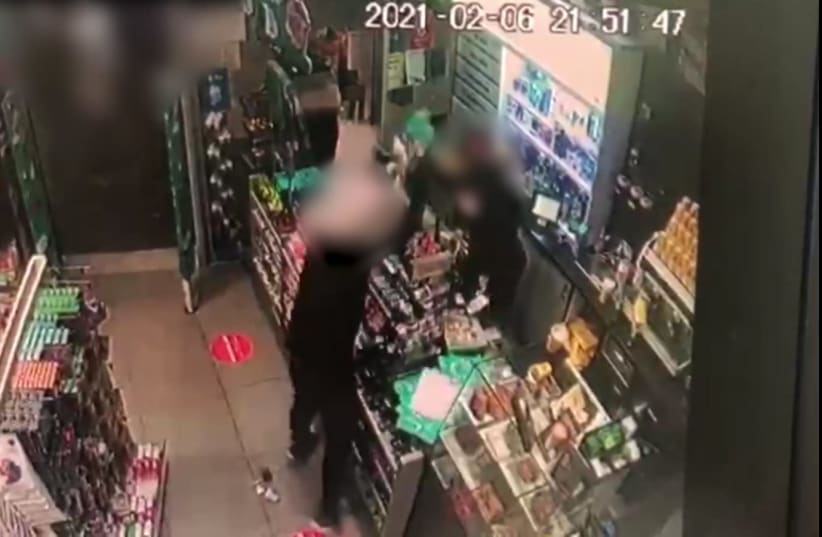 Security footage from the incident shows the suspect raging at the scene, throwing products around the store wildly as his spouse tries to hide in the corner behind a coworker. (photo credit: POLICE SPOKESPERSON'S UNIT)