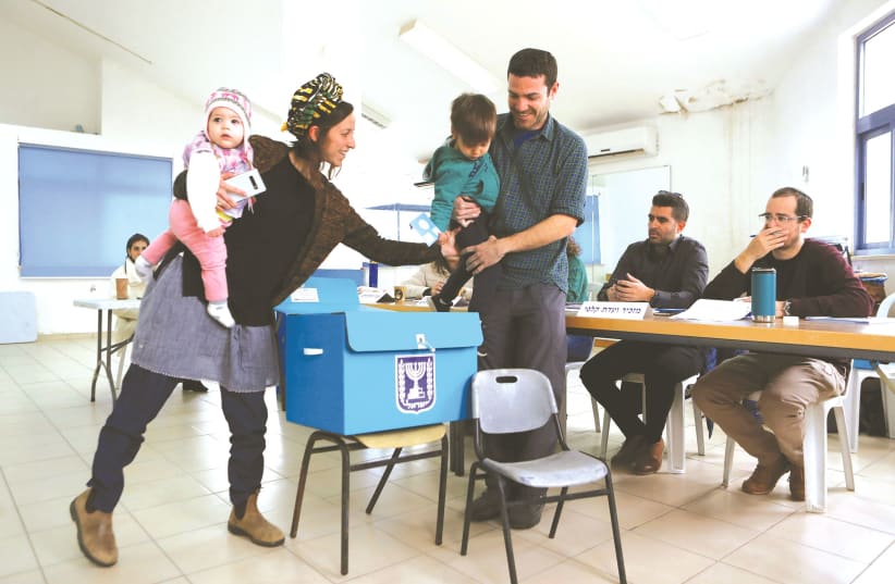 A FAMILY prepares to cast a ballot at a polling station in Nokdim last March. (photo credit: RONEN ZVULUN/REUTERS)