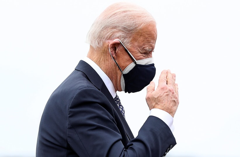 US President Joe Biden returns a salute while boarding Air Force One as he departs Washington for travel to Michigan at Joint Base Andrews, Maryland, US, February 19, 2021. (photo credit: TOM BRENNER/REUTERS)