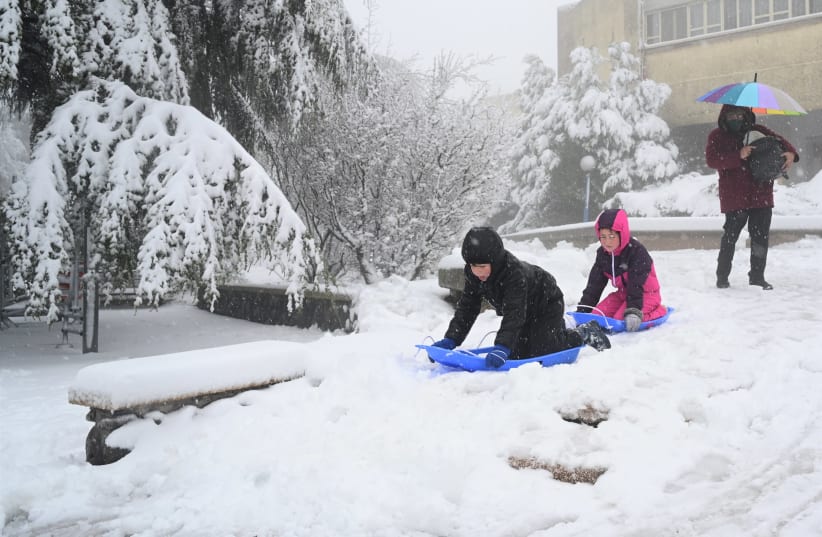People play in the snow in the Golan Heights, Northern Israel. February 18, 2021. (photo credit: MICHAL GILADI/FLASH90)