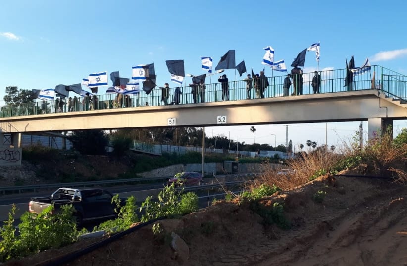 Protesters gather at the Neurim Bridge ahead of week 35 of the Balfour protests against Prime Minister Benjamin Netanyahu, Feb. 20, 2021. (photo credit: AVSHALOM SASSONI/MAARIV)
