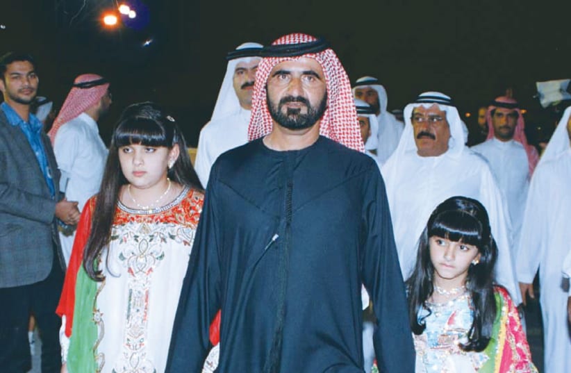 A 1999 PHOTO of Sheikh Mohammed Bin Rashid Al Maktoum, with his traditionally dressed daughters, Sheikha Latifa (left) and Sheikha Mariam.  (photo credit: REUTERS)