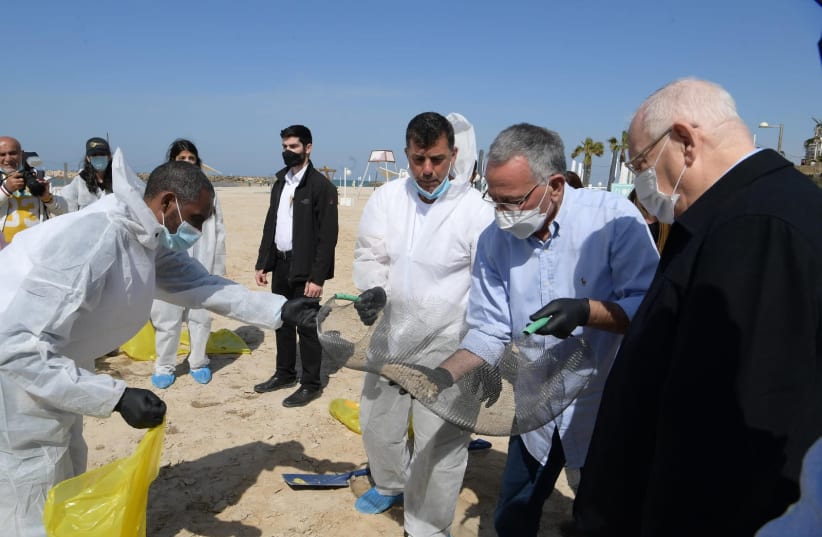 President Reuven Rivlin visits cleanup efforts at Herziliya beach after oil spill (photo credit: AMOS BEN-GERSHOM/GPO)